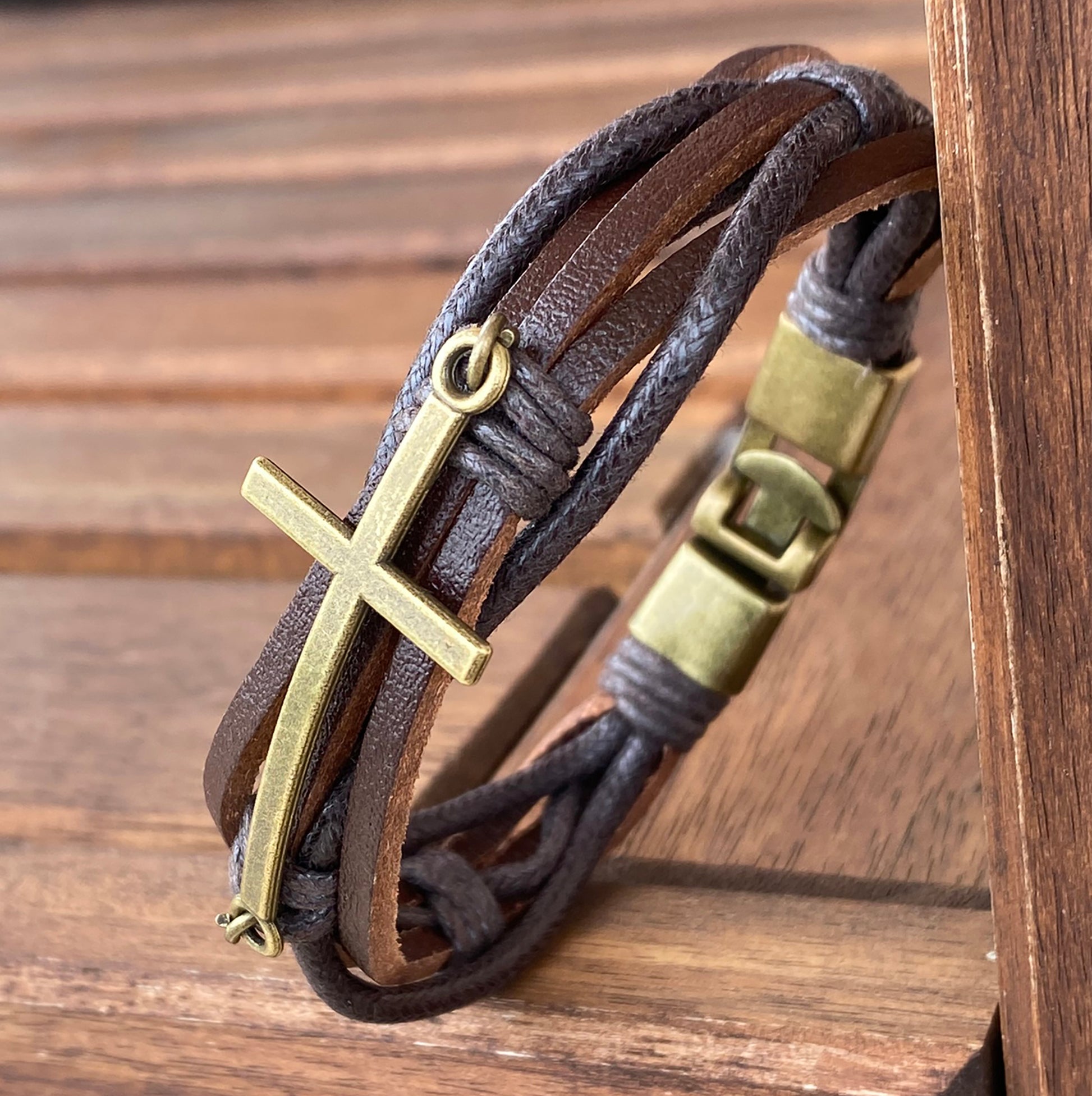 Brown leather Christian bracelet for men with brass cross and brass clasp – close-up view


