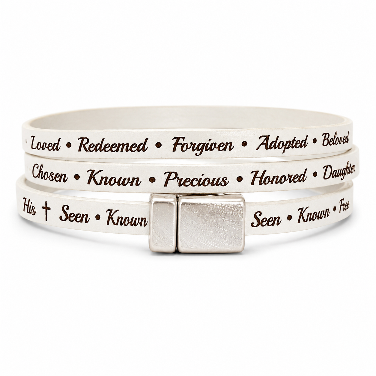 leather wrap-style bracelet with silver-toned rectangular clasp, featuring engraved black text words of affirmation such as 'Loved', 'Redeemed', 'Forgiven', 'Adopted', 'Beloved', 'Chosen', 'Known', 'Precious', 'Honored', 'Daughter', 'His', 'Seen', 'Known', and 'Free'.